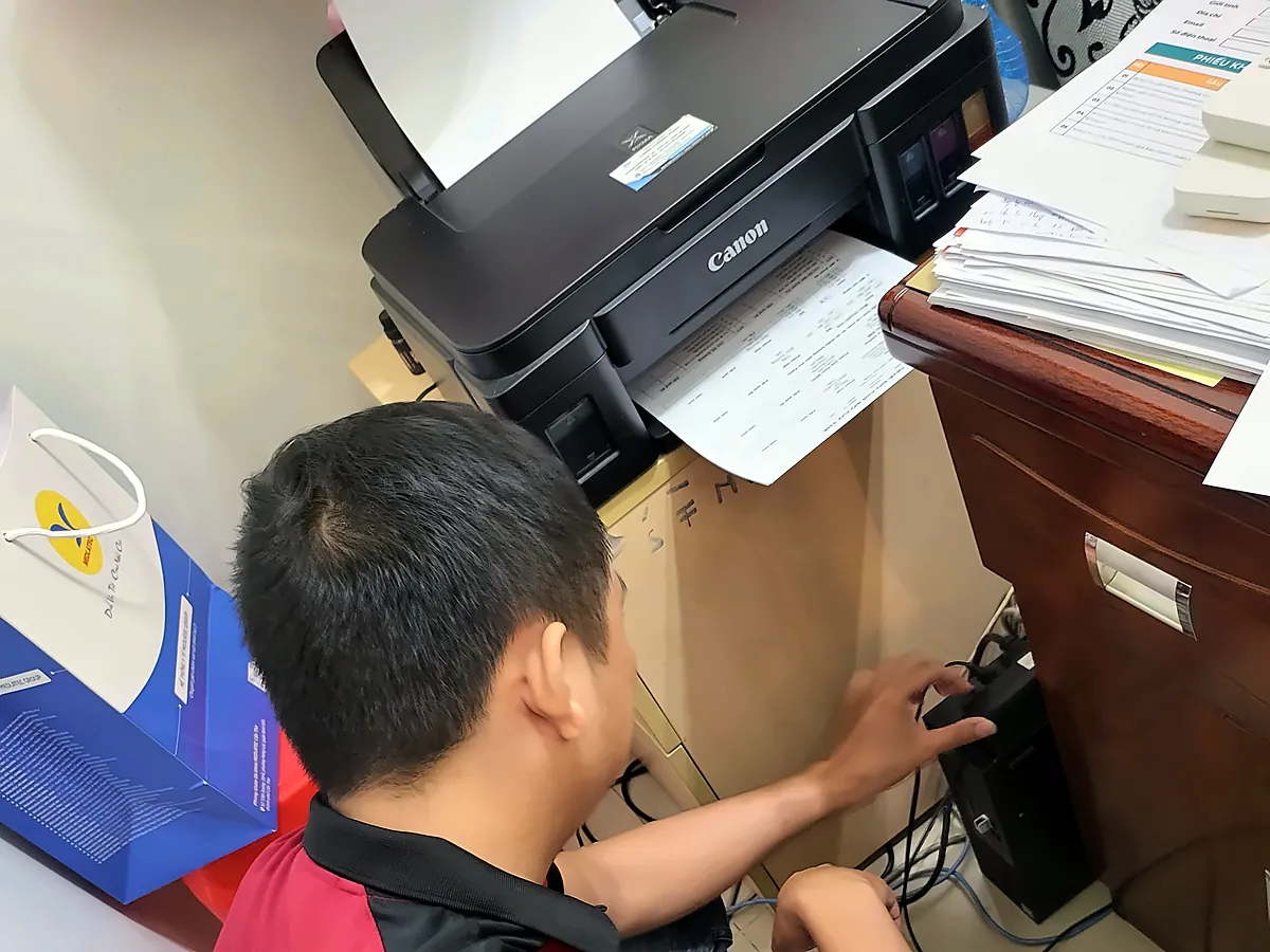 Kỹ thuật viên K39 kiểm tra, đấu nối máy in tại văn phòng khách hàng